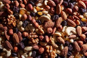 Mixed Nuts. Almonds, Walnuts, Cashews, Peanuts, Hazelnuts, Dried Prunes and Raisins. Different Nut Mix. Background from Various Nuts and Dried Fruits photo