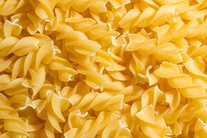 Uncooked Fusilli Pasta. A Culinary Canvas of Spiral Macaroni, Creating a Lively and Textured Background for Gourmet Cooking. Dry Pasta. Raw Macaroni - Top View, Flat Lay photo