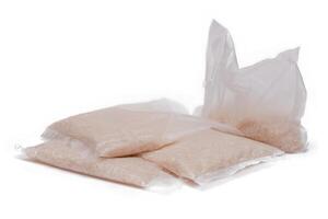 A Plastic Bags of White Long Grain Rice - Isolated on White Background. Small Transparent Packages with Dry Rice - Isolation photo