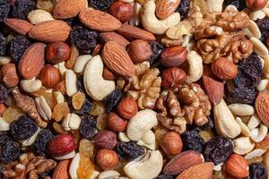 Mixed Nuts. Almonds, Walnuts, Cashews, Peanuts, Hazelnuts, Dried Prunes and Raisins. Different Nut Mix. Background from Various Nuts and Dried Fruits photo