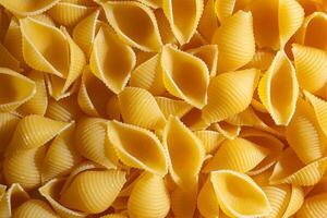 Uncooked Conchiglie Pasta. A Culinary Canvas of Conchiglie Macaroni, Creating a Lively and Textured Background for Gourmet Cooking. Dry Pasta. Raw Macaroni - Top View, Flat Lay photo