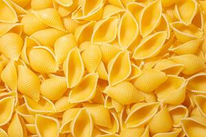Uncooked Conchiglie Pasta. A Culinary Canvas of Conchiglie Macaroni, Creating a Lively and Textured Background for Gourmet Cooking. Dry Pasta. Raw Macaroni - Top View, Flat Lay photo