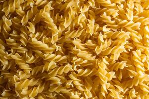 Uncooked Fusilli Pasta. A Culinary Canvas of Spiral Macaroni, Creating a Lively and Textured Background for Gourmet Cooking. Dry Pasta. Raw Macaroni - Top View, Flat Lay photo
