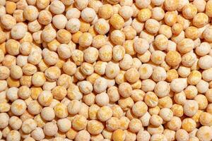 Uncooked Yellow Polished Peas Background. A Culinary Canvas of Dry Yellow Peas, Creating a Lively and Textured Background for Gourmet Cooking. Scattered Raw Polished Peas. Healthy Eating Ingredients photo