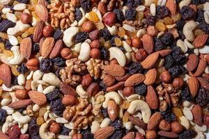 Mixed Nuts. Almonds, Walnuts, Cashews, Peanuts, Hazelnuts, Dried Prunes and Raisins. Different Nut Mix. Background from Various Nuts and Dried Fruits photo
