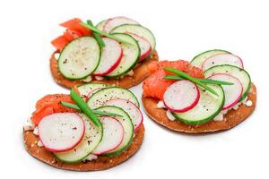 Crispy Cracker Sandwiches with Salmon, Cucumber, Radish, Cottage Cheese and Green Onions - Isolated on White. Easy Breakfast. Quick and Healthy Sandwiches. Crispbread with Tasty Filling - Isolation photo