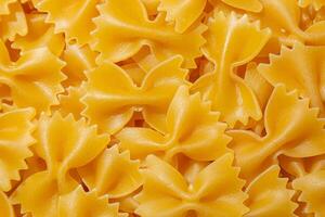Uncooked Farfalle Pasta. A Culinary Canvas of Bow-Tie Macaroni, Creating a Lively and Textured Background for Gourmet Cooking. Dry Pasta. Raw Macaroni - Top View, Flat Lay photo