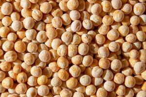Uncooked Yellow Polished Peas Background. A Culinary Canvas of Dry Yellow Peas, Creating a Lively and Textured Background for Gourmet Cooking. Scattered Raw Polished Peas. Healthy Eating Ingredients photo