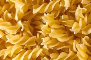 Uncooked Fusilli Pasta. A Culinary Canvas of Spiral Macaroni, Creating a Lively and Textured Background for Gourmet Cooking. Dry Pasta. Raw Macaroni - Top View, Flat Lay photo