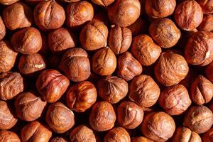 Scattered Peeled Hazelnut - Top View. Background from Hazelnuts. Natural High-Calorie Snacks photo