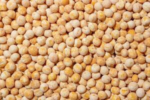 Uncooked Yellow Polished Peas Background. A Culinary Canvas of Dry Yellow Peas, Creating a Lively and Textured Background for Gourmet Cooking. Scattered Raw Polished Peas. Healthy Eating Ingredients photo