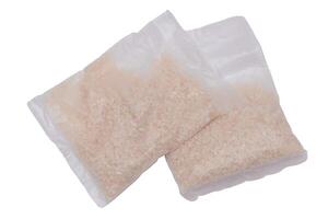 A Plastic Bags of White Long Grain Rice - Isolated on White Background. Small Transparent Packages with Dry Rice - Isolation photo