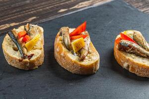 three fish sandwiches on a stone board on the table photo