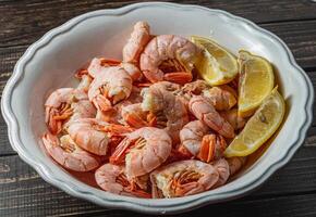 Tiger king prawns cooked and seasoned with lemon, on a wooden table photo