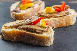 three fish sandwiches on a stone board on the table. selective focus photo