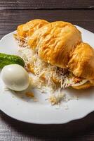 Croissant sandwich with tuna, egg, cucumber and cheese on a white plate photo