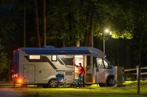 Relaxing Evening at a Campsite With a Camper Van Under the Stars Surrounded by Trees photo