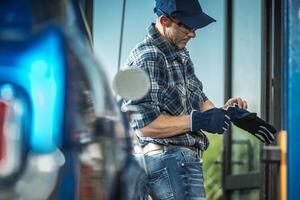 Worker Preparing for a Task at a Service Station on a Bright Day in a Bustling Urban Area photo