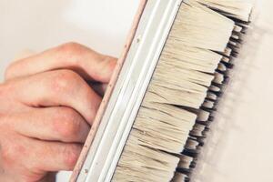 Person Carefully Painting a Surface With a Brush Using Precise Strokes in a Well-Lit Workspace photo