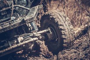 Off-road Vehicle Tackling Muddy Terrain in the Wilderness During Daytime Adventure photo