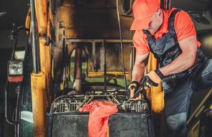 Mechanic Repairing Heavy Machinery in Workshop During Daytime With Focus on Engine Maintenance photo