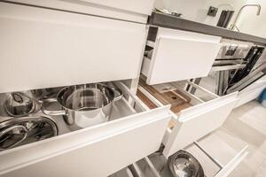Modern Kitchen With Open Drawers Showcasing Organized Cooking Pots and Utensils in a Sleek Design photo