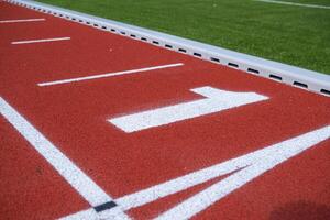 Running Track Lane One Marked on a Red Athletic Field Ready for Competition During Daylight Hours photo