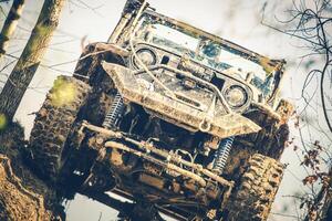 Off-road Vehicle Climbing a Muddy Hill During a Daytime Adventure in the Forest photo