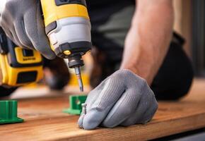 Man Using a Power Drill to Fasten Screws During a Home Improvement Project in the Afternoon photo