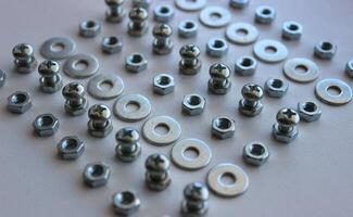 Macro photo of square laid out from separate rows of metal ironware products on white workbench