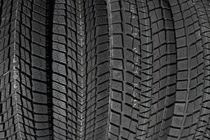 Closeup image of textured pattern of directional tread blocks and large sipes on winter non studded tires photo