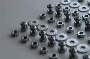 Metal Steel Fastener And Fixing Parts In Even Lines On Plastic Surface Detailed Stock Photo. Ironware Goods Royalty Free Background photo
