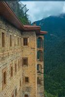 Exterior view of Sumela Monastery and forest covered mountains on the background photo