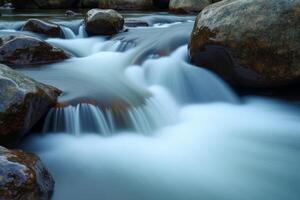 A stream of water flowing over rocks in a river photo