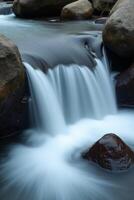 A waterfall flowing over rocks in a river photo