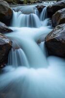 A waterfall flowing over rocks in a river photo