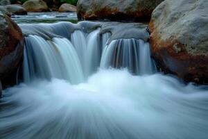 A waterfall flowing over rocks in a river photo
