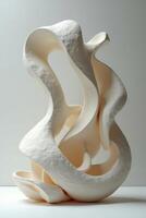 A sculpture made out of white clay with a curved shape photo