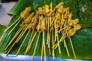 Authentic Thai Pork Satay with Creamy Peanut Sauce, Topped with Shallots and Spicy Fresh Chilies photo
