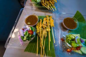 Authentic Thai Pork Satay with Creamy Peanut Sauce, Topped with Shallots and Spicy Fresh Chilies photo