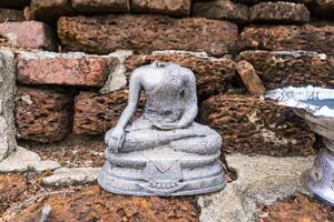 Ancient Headless Buddha Statue Amidst Weathered Bricks - A Symbol of Time's Passage and Cultural Heritage photo