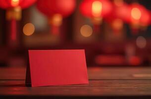 Red envelope on wooden table with lanterns in background. Chinese New Year. photo