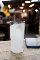 Glass of covered with frost on wood table photo