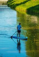 Nitra, Slovakia - 06.15.2022 A young man is sailing in a canoe on the Nitra river. photo