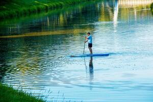 Nitra, Slovakia - 06.15.2022 A young man is sailing in a canoe on the Nitra river. photo