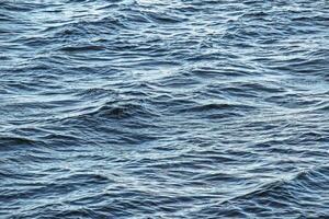 The background of the surface of the water of the river with small ripples and reflections of autumn colors. photo