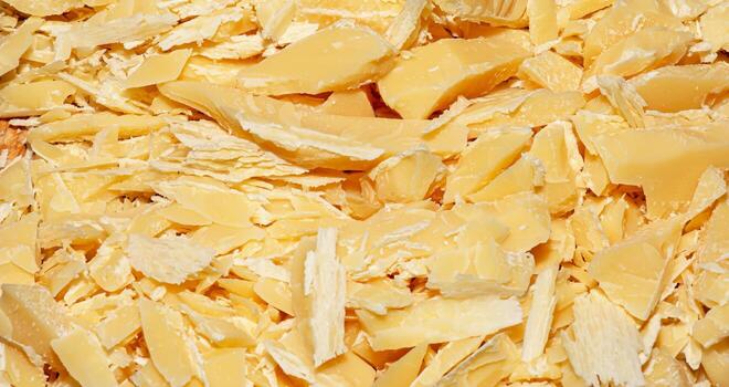 Cocoa butter background, top view, texture. Cocoa butter is one of the ingredients in making chocolate at home. Close-up of crushed cocoa butter, top view. photo