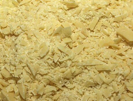 Cocoa butter background, top view, texture. Cocoa butter is one of the ingredients in making chocolate at home. Close-up of crushed cocoa butter, top view. photo