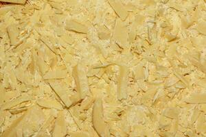 Cocoa butter background, top view, texture. Cocoa butter is one of the ingredients in making chocolate at home. Close-up of crushed cocoa butter, top view. photo
