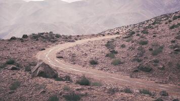 Winding dirt road in the Pamir Mountains during a cloudy day in Tajikistan video